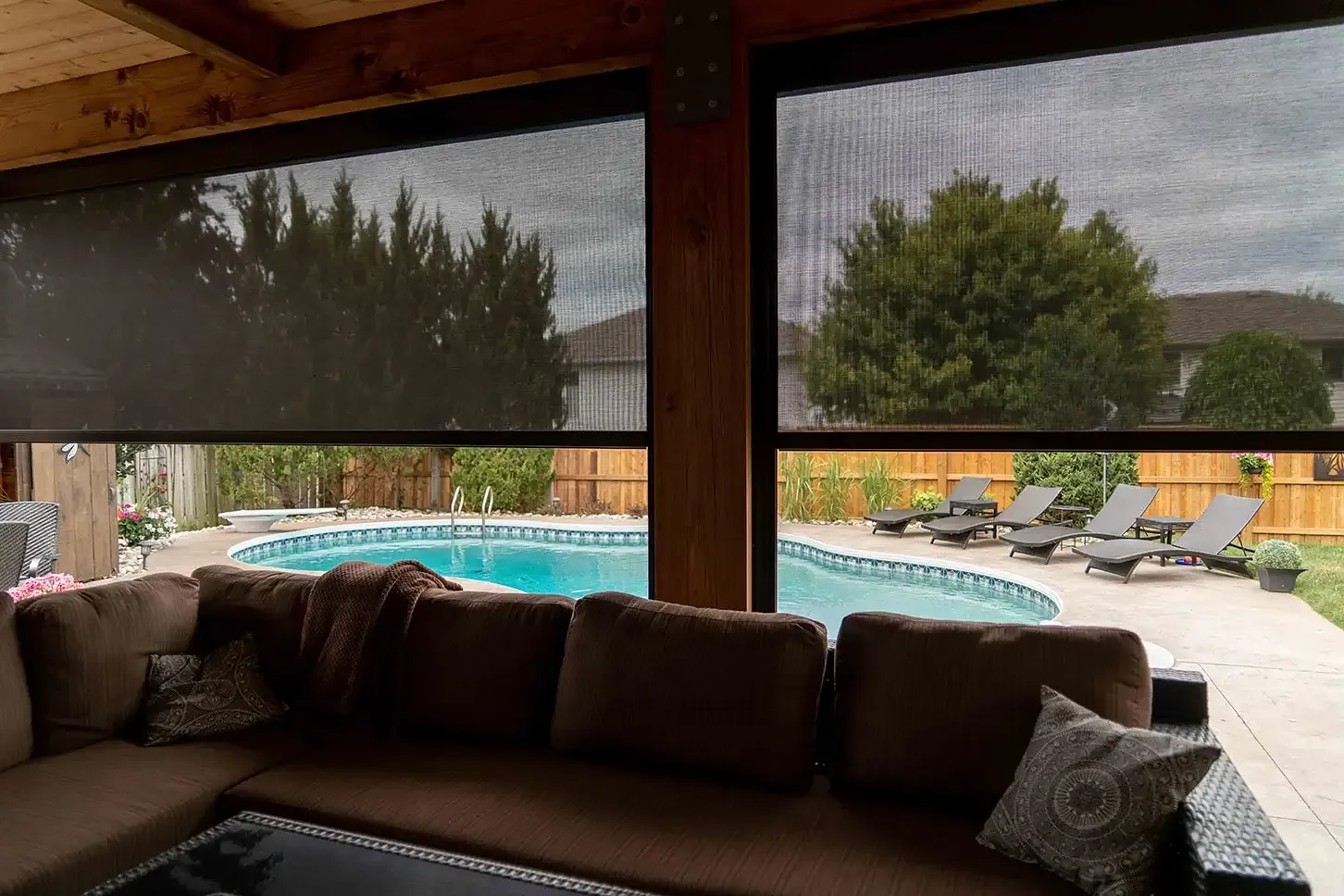 Backyard pool framed through a deployed solar mesh