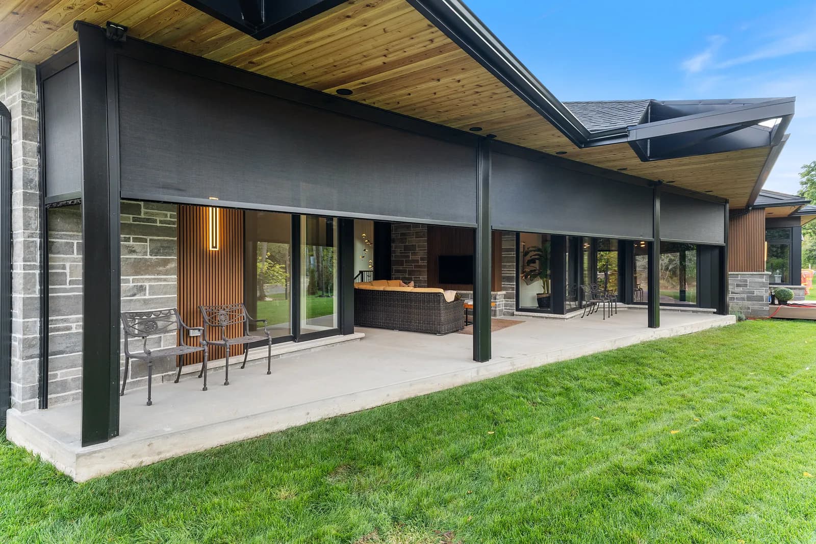 Modern luxury home with long deployed dark mesh covered porch