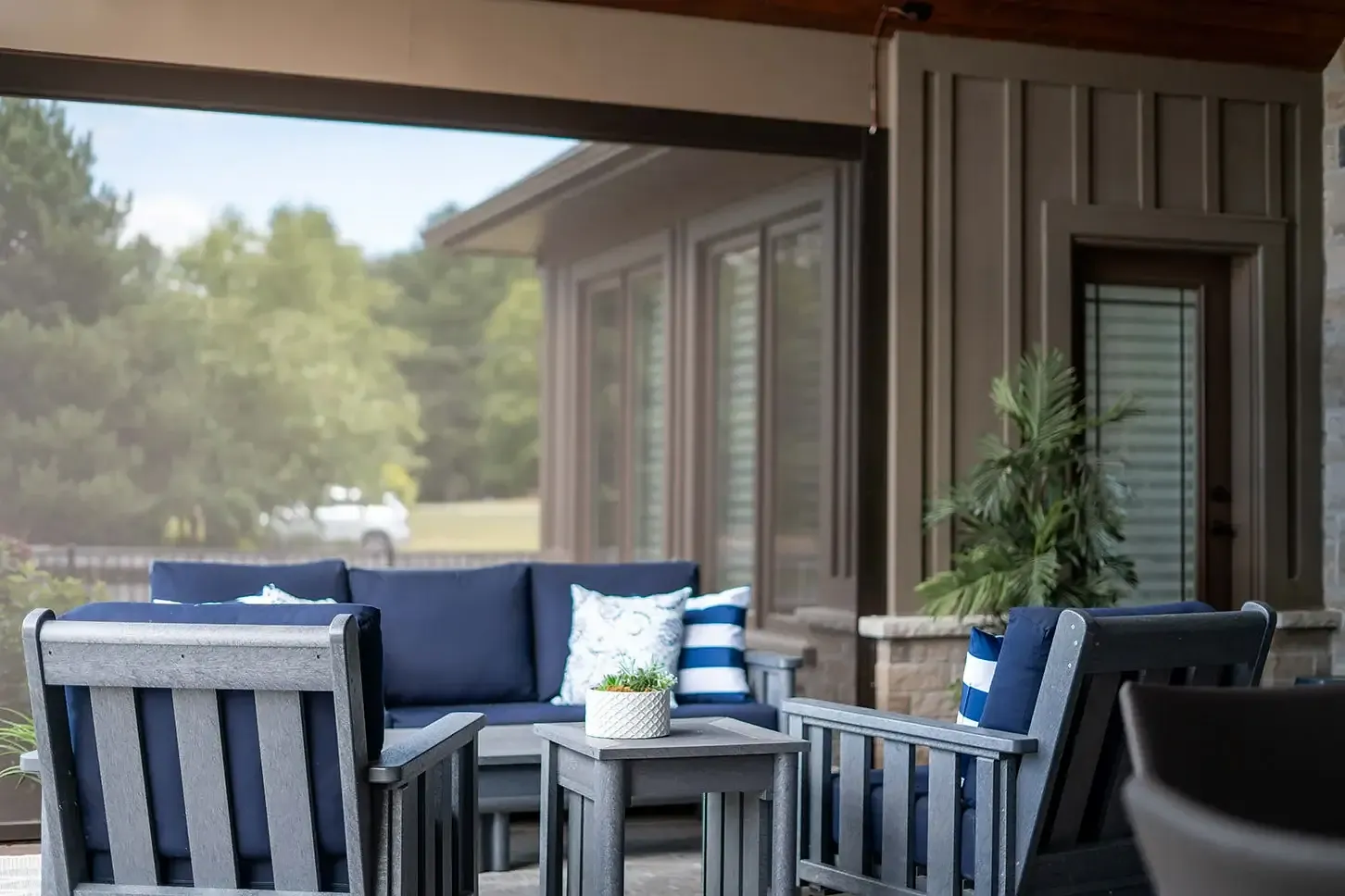 Inside view of covered porch with retracted screens and navy cushions